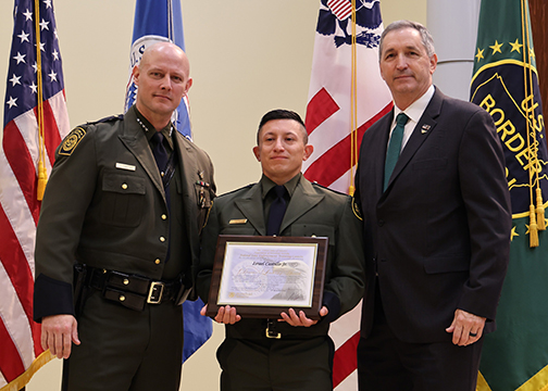 Border Patrol Agent Israel Castillo, Jr. (Center), is awarded the FLETC Director's Leadership Award presented by the FLETC Director Benjamine C. Huffman (Right) alongside of the U.S. Border Patrol Chief Jason Owens (Left). 