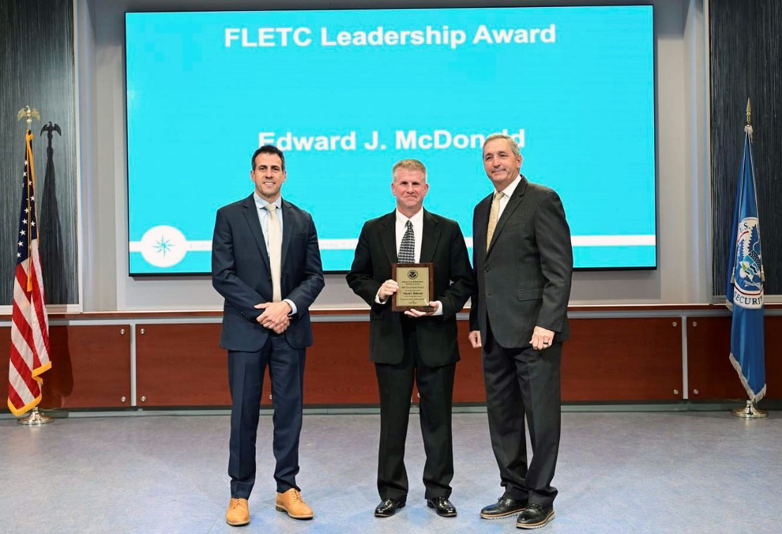 Edward J. McDonald, Federal Law Enforcement Training Centers (FLETC), Investigative Operations Division, Technical Training Operations Directorate, received the Leadership Award for 2023, presented by FLETC Director Benjamine C. Huffman (Right) and FLETC Deputy Director Kai J. Munshi (Left) at the FLETC Annual Awards Ceremony, at Glynco, Ga. on June 12, 2024. (Photo by David Tucker, OPA)