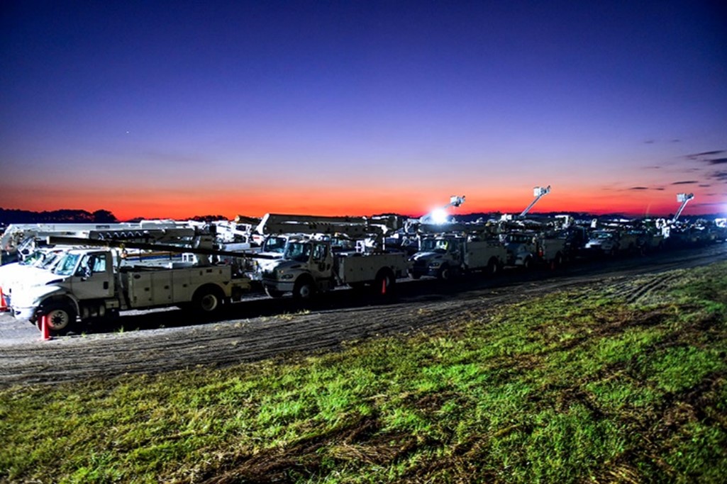 Bucket trucks line the Federal Law Enforcement Training Centers driving range ready for deployment to fix power outages across the southeast Georgia, in Glynco, Ga., Oct. 3, 2024. 