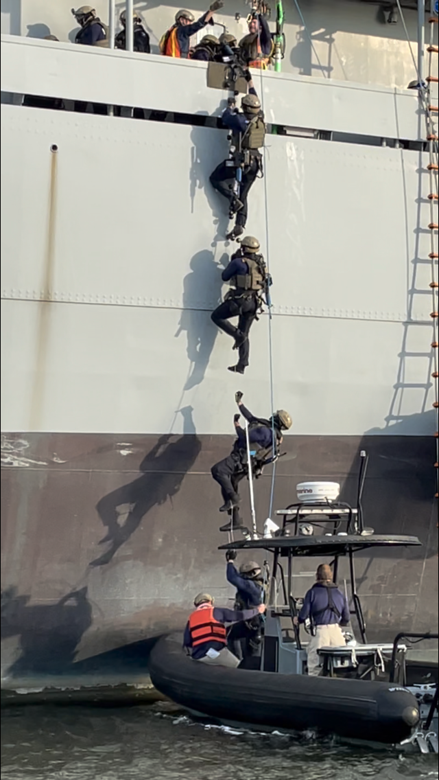 Students performing a “hook and climb” maneuver off the side of the Cape Chalmers
